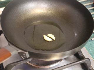 2、百变鸡蛋+迷你蔬菜烘蛋,铁锅放入橄榄油和拍破的大蒜，小火将大蒜炒出香味。