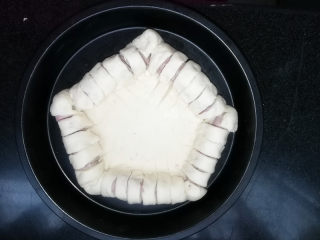 7、满园春色香肠披萨,用锋利的小刀均匀的切出口子，要将香肠和包裹的面团一起切开。