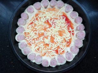 11、满园春色香肠披萨,将酱料抹匀后，铺上一层马苏里拉芝士。