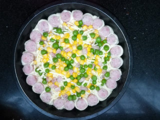 13、满园春色香肠披萨,再铺上一层豌豆、玉米和香肠。