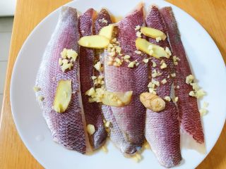 1、馋嘴版家庭烤鱼,鱼柳放在盘中，加入两汤匙料酒，撒上蒜米和姜片腌制15分钟。
