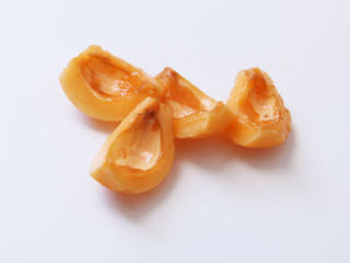 4、蜜渍枇杷,把核去掉。核与果肉之间有一层膜，要是有时间，就把这层膜撕掉。再切一刀，一颗枇杷分成四瓣。