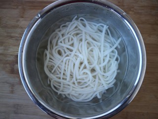 5、三合油拌面,把煮熟的面条捞入凉水中过一遍，倒出凉水。