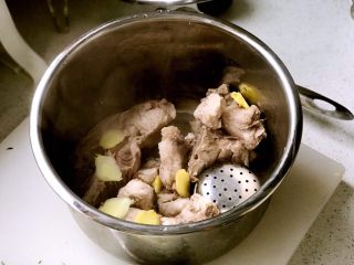 3、暖心排骨汤,把飞水之后的排骨捞出放进高压锅，同时放入姜片和调味盒；