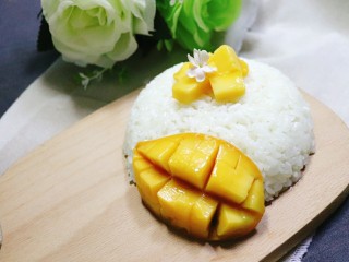 9、芒果糯米饭,最后把一半的芒果切花侧摆在米饭一边即可。