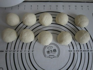 6、葡萄干小餐包,将醒好的面团分成10个小面团滚圆，盖上保鲜膜松弛15分钟。