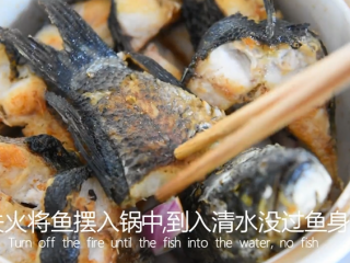 9、饭店绝对吃不到，这样做鱼肉超级美味下饭！,关火用洋葱块铺平砂锅，将鱼摆入锅中，倒入清水没过鱼身