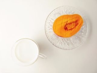 7、芒果西米露,牛奶中加适量细砂糖，拌匀，芒果切块（处理芒果，贴核切开，用刀划井字（底部不要划破外皮），再贴着皮将果肉取下）