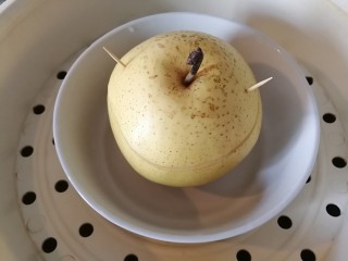 9、冰糖雪梨,把切去部分放在上盖好。用牙签固定。放入蒸锅内蒸45分钟。