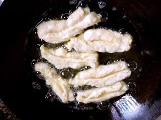 7、家庭健康小油条,锅放约800毫升的油，烧至七成热，把面条拉长下油锅炸。