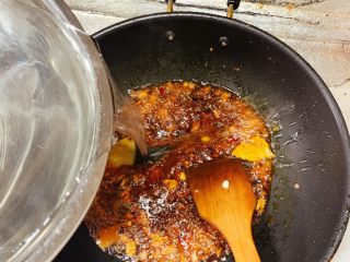 13、家庭版水煮肉片,火锅底料花开后加入适量高汤或者开水，大概能刚好没过等会准备的配菜即可