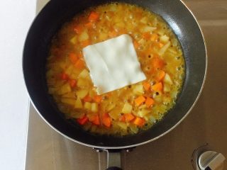 12、咖喱芝士热狗意面,汤烧开至咖喱块完全融化后，转开小火，同时放入芝士片；