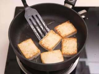 2、日式豆浆蔬菜锅,热锅入油，加入豆腐，煎至表面金黄，再起锅备用。