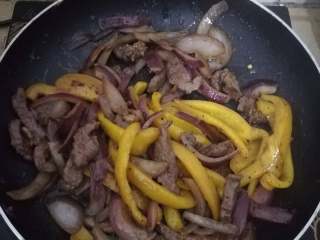 13、黑椒牛柳意面,等洋葱炒得基本都透明时，彩椒也应该全熟了，倒入牛肉，撒上海盐，黑胡椒末，迷迭香，罗勒叶碎，快速翻炒两下即可