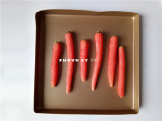 6、秘制烤胡萝卜,将胡萝卜放进不粘烤盘；如果烤盘会粘，需垫锡纸或油纸；