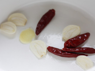 4、深夜食堂之酒蒸花蛤,油微微加热后放入姜片、蒜片和红干椒,翻炒爆香防止焦糊