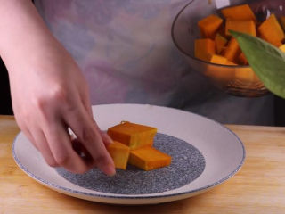 9、这样做的南瓜饼，才是最好吃的！,取一个盘子，在盘子的中间摆上一块南瓜（如果肉的量够多的话也可以不用再中心放南瓜呢）。