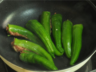 7、青椒酿肉,锅烧热,倒入少许油,烧热后将青椒摆在平底锅里煎,将有肉的一面朝下,小火慢煎