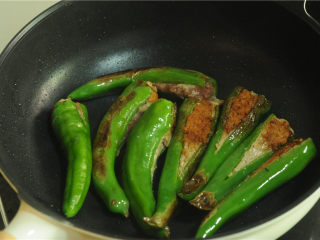 8、青椒酿肉,待煎至肉变色,翻面,小火煎制另一面