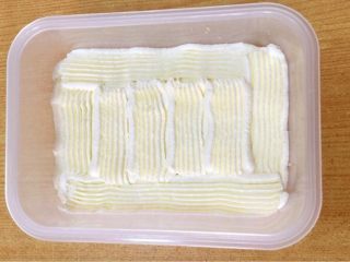 6、水果便当蛋糕 #乐享双节#,奶油装进裱花袋，在蛋糕片上裱上一层奶油。