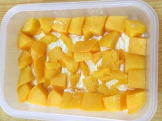 7、水果便当蛋糕 #乐享双节#,摆上一层芒果粒，规整的尽量放四周一圈，中间放些碎粒即可。