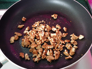 9、#菌类料理#木耳凉拌核桃仁,趁着刚刚的油锅将核桃仁放入、然后开中小火将其炒香炒熟