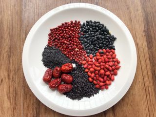 1、补血养颜粥,首先把食材准备好，黑米40g，黑豆40g，黑芝麻30克，红豆40克，花生50克，红枣6颗，放入盘里待用。