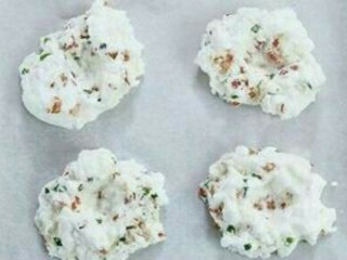 3、培根芝士云朵蛋,将蛋清分好份放在烤盘上，并扣出个洞洞来，入烤箱220℃烤三分钟