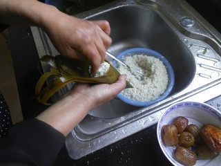 9、传统红枣粽,放入红枣后，在用勺子挖少许糯米，将红枣盖住即可。接着在用手把糯米给推紧实一点