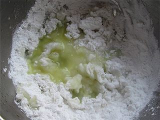 4、清明果,先将澄面中加入的开水40克，搅拌均匀后，倒入准备好的糯米粉，然后分次加入约100克左右的艾青汁，揉成一个绿色的面团。