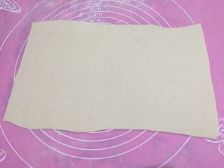 3、肉龙,如图发酵好的面团充分排气，分成均匀的四份，取其中一份擀成长圆形，可以把两边的圆形切掉，就成了一个长方形（传统的面皮会很厚，我做的比较薄，大概比饺子皮稍厚一点。）