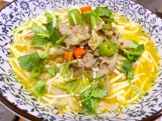 9、酸汤肥牛卷,入肥牛卷和金针菇煮开，关火，撒香菜，淋热油即成。