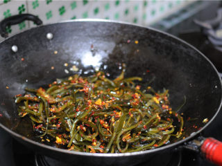11、麻辣海带丝,快速翻炒,让海带丝均匀地粘上佐料,撒上葱花即可出锅