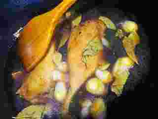 6、#年夜饭#酱鸭肉,煎好以后加入葱姜蒜八角和香叶翻炒几下， 加入适量冰糖， 再加入适量的料酒， 加入适量生抽，清水，没过鸭腿， 盖盖子小火炖半小时