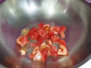 3、#懒人料理#番茄鸡蛋疙瘩汤,锅热倒油、爆香葱白后放入番茄、煸至软烂出汁后、倒入适量清水加盖大火