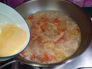 7、#懒人料理#番茄鸡蛋疙瘩汤,接着将蛋液沿着锅边一圈倒入