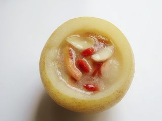 11、自制昙花蒸梨止咳露,再放入枸杞蒸2分钟,关火取出梨盅加入冰糖碎,加过的可不再加