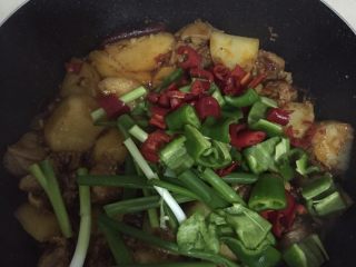 8、大盘鸡,汤汁颜色变深，加青红椒、葱段，盖锅盖再焖2-3分钟。