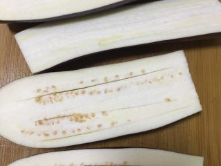 1、烤箱版烤茄子,茄子洗净，对半切开，这根茄子太长了，所以又切成两截，在茄子上划几刀，容易烤熟还有入味