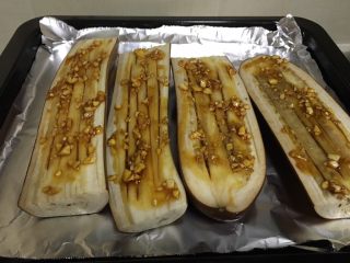 3、烤箱版烤茄子,取出，浇上酱汁，就是蚝油加蒜头，再烤15分钟