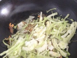 8、秘制温州特色海鲜炒粉干,汁收差不多,就可以拿锅铲和筷子翻炒,加入球菜、虾干继续炒。虾干不能放太早,太硬不好吃