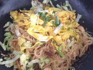 9、秘制温州特色海鲜炒粉干,一开始粉干会有点粘锅,可用锅铲铲掉,后面就不太粘锅,因为料里面的油自己会出来,再加入蛋丝和葱段,建议盖锅盖小火闷半分钟