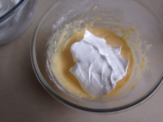 9、不上火的蒸蛋糕,取三分之一打发好的蛋白霜，放入到蛋黄糊里，用刮刀从底部向上翻拌均匀，不要划圈搅拌。