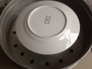 13、不上火的蒸蛋糕,将模具放进蒸笼里，用碟子盖住蛋糕模