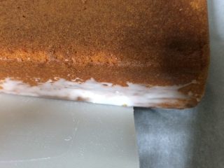 17、淋面柠檬香草磅蛋糕,首先，将蛋糕转移到烹饪板上，并使用一张卡轻轻将一个玻璃箭头应用于侧面的底部。