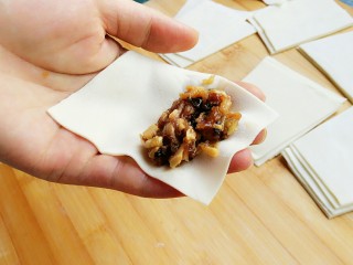 21、石蛤蟆水饺（博山水饺的包法）,开始包饺子，将饺子皮放在伸平的左手掌上，梯形的上底（小头）朝指尖方向。将馅料放在小头的一端。