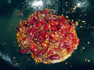 16、香辣烤鱼,炒锅内加入100g色拉油中大火烧至四成热，依次下入郫县豆瓣酱，豆豉，干花椒，辣椒粉，辣椒段炒出红油，加入一半酥花生翻炒均匀提香。