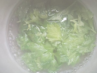 4、健康营养芹菜叶醋拌木耳,锅中烧开水，放少许盐，倒入芹菜叶。