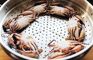 4、海鲜家宴,将螃蟹肚脐冲上摆在笼屉中，撒一丁点盐；