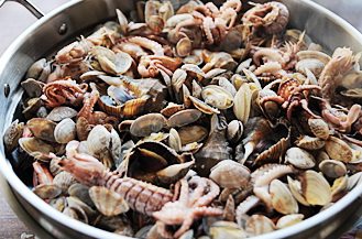 6、海鲜家宴,开盖，在笼屉上铺上琵琶虾，盖盖继续蒸5-8分钟，再开盖放入海螺继续蒸3分钟，开盖放入八带和蛤蜊，撒一丁点盐，盖盖蒸大约2-3分钟，开盖用锅盖扇动蒸锅上方的热气，促使蛤蜊开口后关火取出笼屉，将香葱末和香菜末洒在羊腿汤上，可以按照自己喜好加点胡椒粉，无需加盐。